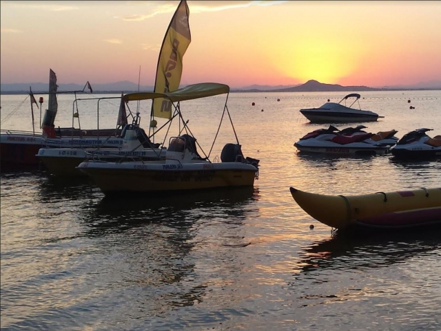 Barcos y motos al atardecer